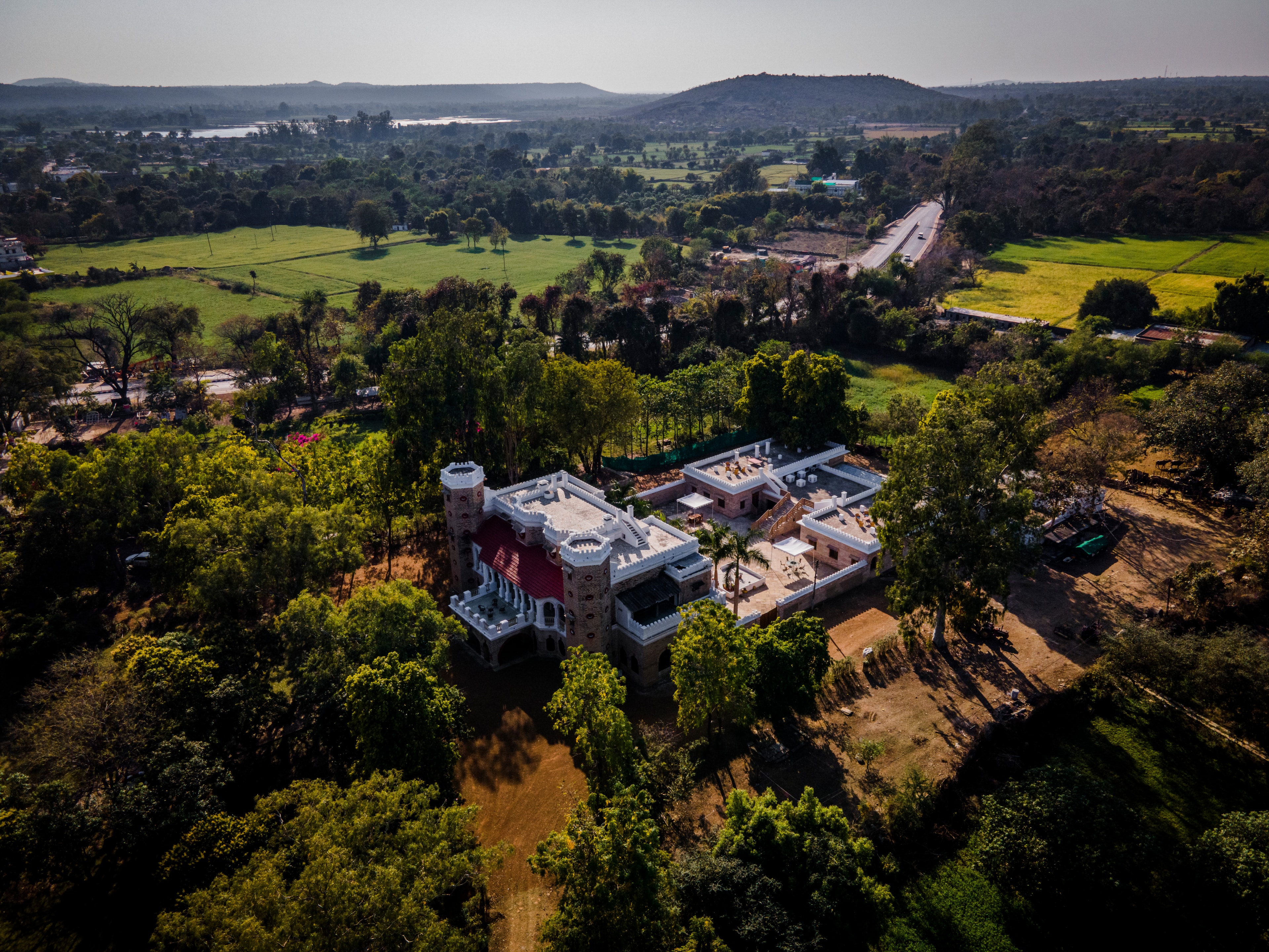 Aerial drone view of Mohanniwas Palace surrounded by lush greenery in Panna